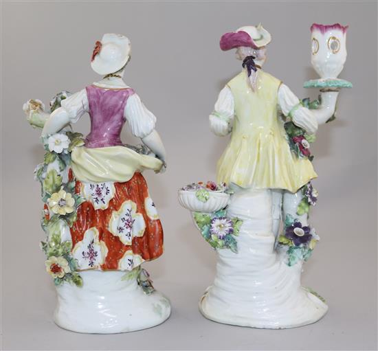 A pair of Derby candlestick figures of a gentleman and a lady, 24cm, damaged